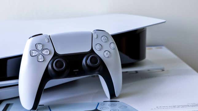 A DualSense controller leans against a PS5 on top of PlayStation 5 retail packaging.
