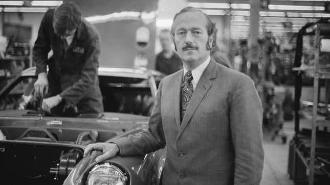 A black and white photo of Lotus founder Colin Chapman in his factory in North London. 