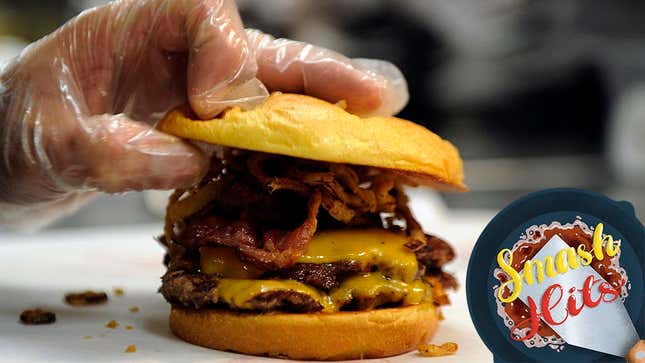Hand placing top burger bun on finished smash burger