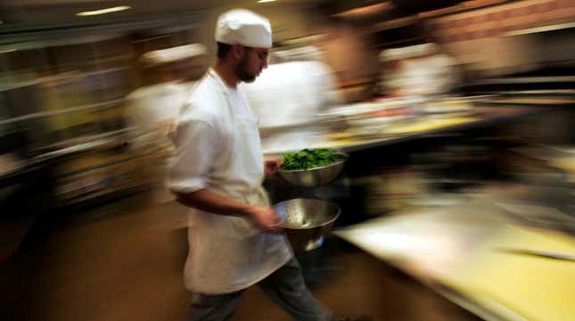 A culinary student hurries through a kitchen