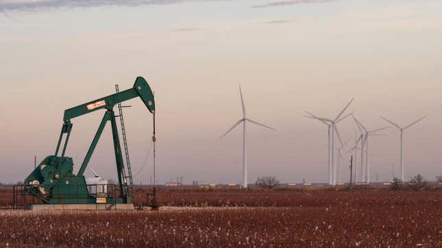 Wind turbines behind an oil pumpjack in Stanton, Texas.