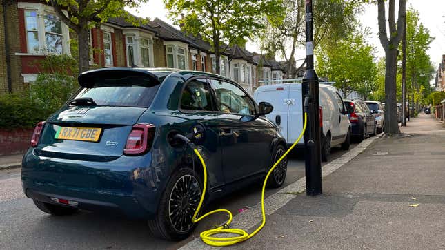 A photo of a Fiat 500 EV charging at a lamp post. 