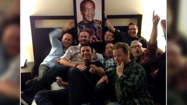 Former World of Warcraft developer Alex Afrasiabi and other Blizzard developers posing with a portrait of Bill Cosby at BlizzCon 2013. 