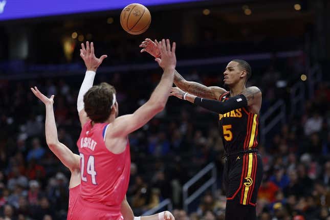 Mar 8, 2023; Washington, District of Columbia, USA; Atlanta Hawks guard Dejounte Murray (5) leaps to pass the ball over Washington Wizards forward Corey Kispert (24) in the first quarter at Capital One Arena.