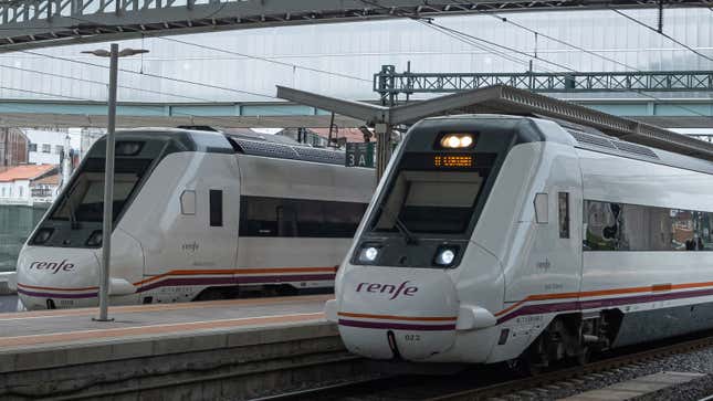 A photo of two trains at a station in Spain.