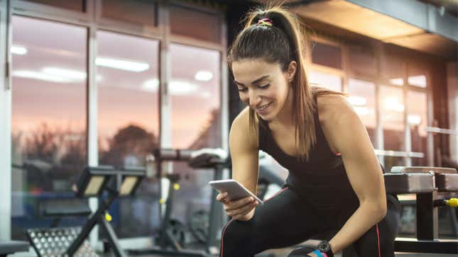 woman looking at phone in the gym