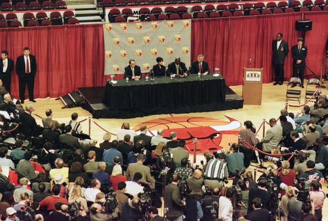 The media are gathered on the floor of the basketball court as Michael Jordan of the Chicago Bulls announces his retirement from the NBA during a press conference at the United Center in Chicago, Illinois.