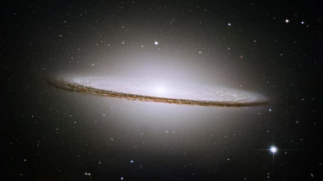 A brilliant white core is encircled by thick dust lanes in this spiral galaxy, seen edge-on. The galaxy is 50,000 light-years across and 28 million light years from Earth.
