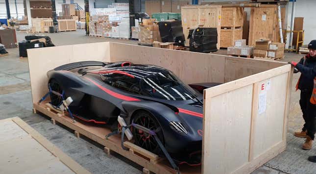 A red and black Aston Martin Valkyrie is being crated up to ship to a customer.