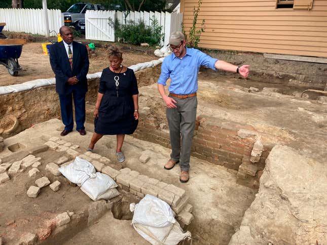 Reginald F. Davis, from left, pastor of First Baptist Church, Connie Matthews Harshaw, a member of First Baptist, and Jack Gary, Colonial Williamsburg’s director of archaeology, stand at the brick-and-mortar foundation of one the oldest Black churches in the U.S. on Oct. 6, 2021, in Williamsburg, Va. Archaeologists in Virginia began excavating three suspected graves at the site on Monday, July 18, 2022, commencing a months-long effort to learn who was buried there and how they lived.