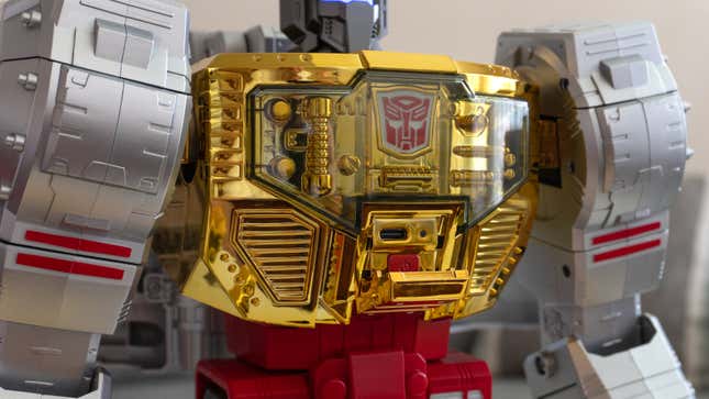 A close-up of an access panel on Robosen and Hasbro's Transformers Grimlock Auto-Converting Robot Flagship Collector’s Edition's chest revealing its power button and USB-C charging port.