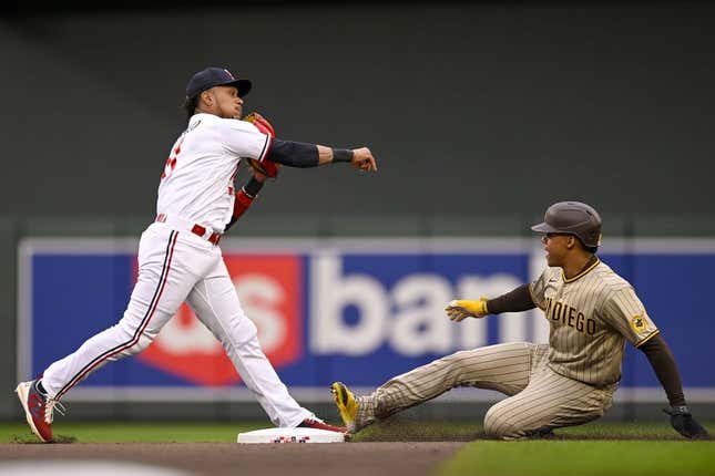 May 9, 2023; Minneapolis, Minnesota, USA;  Minnesota Twins infielder Jorge Polanco (11) throws over San Diego Padres outfielder Juan Soto (22) to complete a double play during the second inning at Target Field.