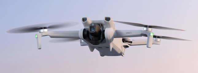 The new DJI Mini 3 in flight against a pastel pink and blue backdrop.