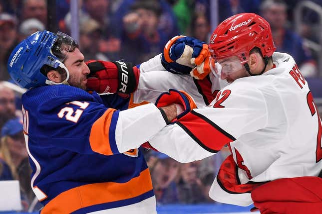 Apr 21, 2023; Elmont, New York, USA; New York Islanders center Kyle Palmieri (21) and Carolina Hurricanes defenseman Brett Pesce (22) fight during the second period in game three of the first round of the 2023 Stanley Cup Playoffs at UBS Arena.