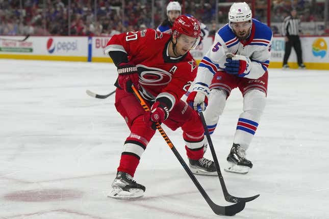 Mar 23, 2023; Raleigh, North Carolina, USA; Carolina Hurricanes center Sebastian Aho (20) skates with puck past New York Rangers defenseman Ben Harpur (5) during the first period at PNC Arena.