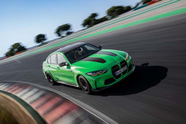 A bright green 2024 BMW M3 CS corners on a race track