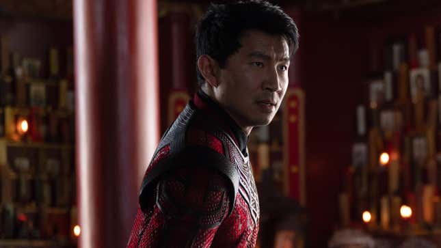 Simu Liu wearing a red superhero suit in a red room in a scene from Marvel's Shang-Chi and the Legend of the Ten Rings.
