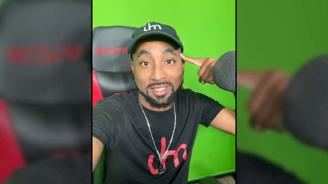 Detrick Houchens smiles while he sits in his Respawn gaming chair in front of his green screen. 
