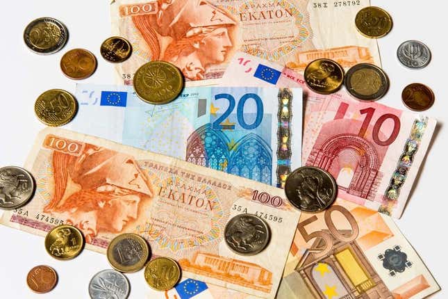 A collection of old Greek drachma and euro notes and coins, pictured in Brussels, in 2012.