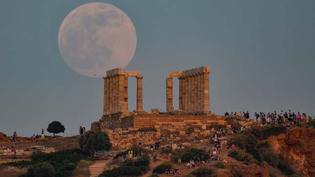 A photo of the moon behind a monument in Greece. 