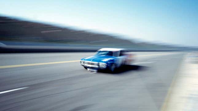 A blurred photo of a car racing on a track.