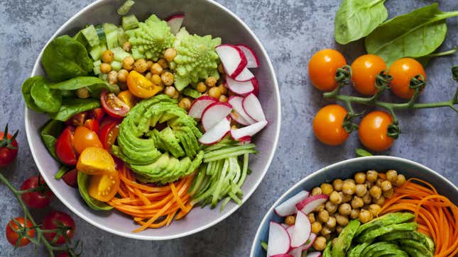 Vegan bowl with romanesco, avocado, carrots, tomatoes, and more