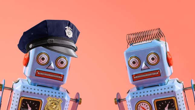 Two identical robots, one dressed as a police officer.