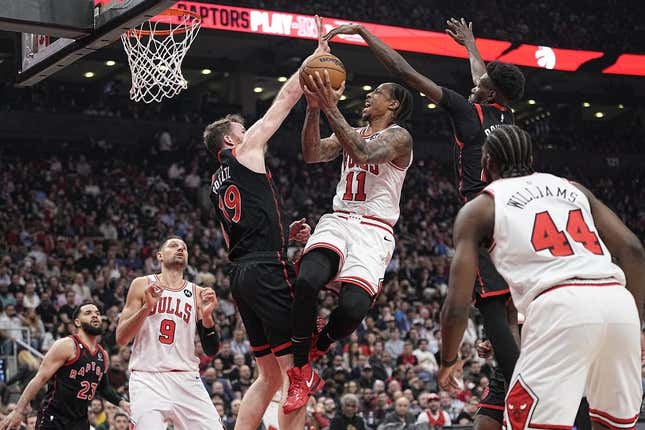 Apr 12, 2023; Toronto, Ontario, CAN; Toronto Raptors center Jakob Poeltl (19) and forward Chris Boucher (25) block a shot attempt by Chicago Bulls forward DeMar DeRozan (11) during the NBA Play-In game at Scotiabank Arena.