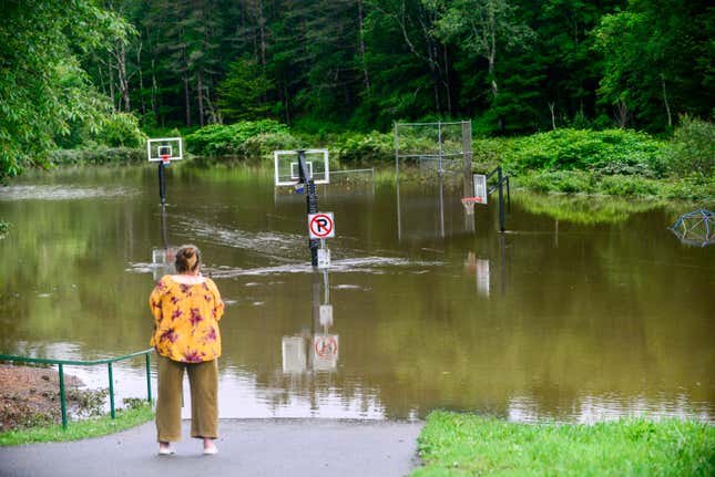 Karen Matter, of Amherst, N.H., takes a video of the flooding from the North Branch Deerfield River in Wilmington, Vt., on July 10, 2023.