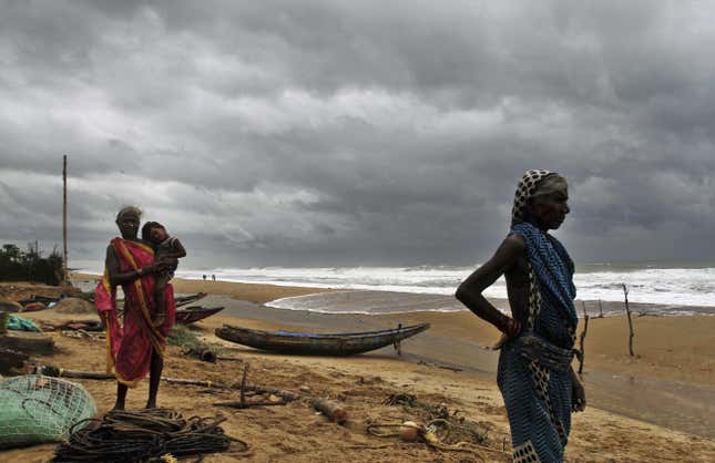 Fisherwomen watch the sea waves before evacuating the place near Podampeta village, on the outskirts of Gopalpur beach in Ganjam district, 140 kilometers (87 miles) south of Bhubaneswar.