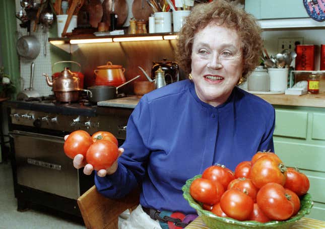 In this Aug. 13, 1992 photo, chef and author Julia Child holds tomatoes in the kitchen of her home in Cambridge, Mass.