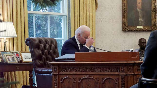 President Joe Biden speaks by phone in the Oval Office.