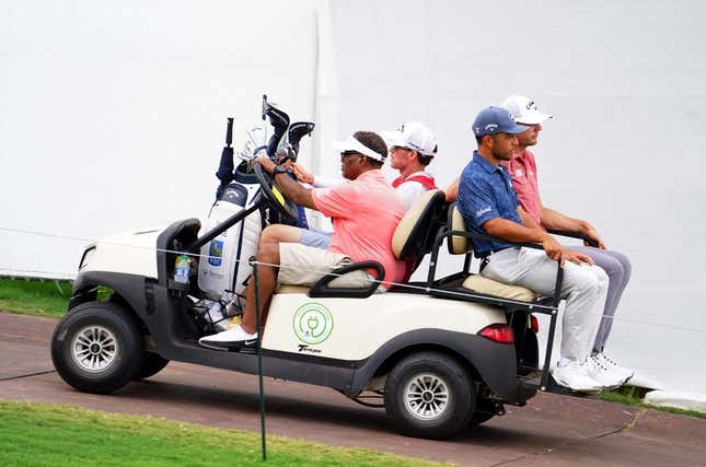 Aug 26, 2023; Atlanta, Georgia, USA; Xander Schauffele and Sam Burns are carted off the course after the horn was blown for a weather delay during the third round of the TOUR Championship golf tournament at East Lake Golf Club.