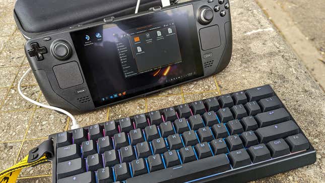A Steam Deck and keyboard sit on a park table.