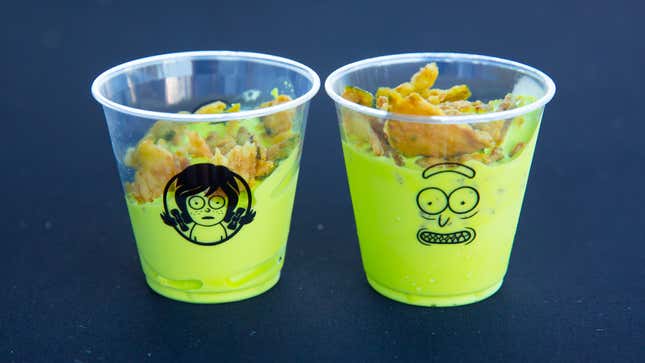 Two plastic cups adorned with Rick and Morty-style art and filled with bright-green Pickle Rick Frosties.