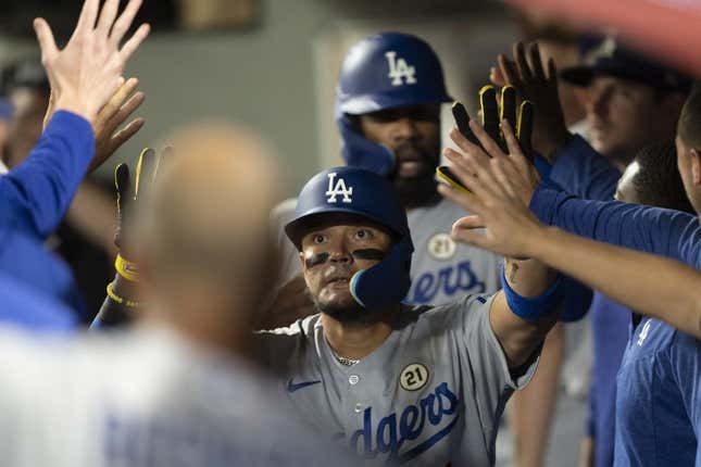 Sep 15, 2023; Seattle, Washington, USA; Los Angeles Dodgers shortstop Miguel Rojas (11) is congratulated by teammates in the dugout after hitting a two-run home run against the Seattle Mariners at T-Mobile Park.