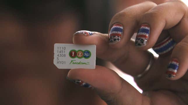 An anti-government protester holds up a SIM card before cancelling their AIS subscription during a rally at the Shinawatra building in central Bangkok March 10, 2014. AIS was founded by Thaksim Shinawatra, brother of current Prime Minister Yingluck. REUTERS/Chaiwat Subprasom