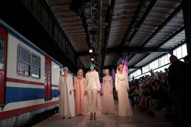 Models hit the runway of a fashion show during the International Modest Fashion Week, in Istanbul, Friday, May, 13, 2016. Turkeys first International Modest Fashion Week has opened in Istanbul bringing designers and models of conservative wear from around the world. The two-day event kicked off Friday with models hitting the runway at a historic train station donning a bright palette of breezy garment and kaleidoscopic headscarves. (AP Photo/Lefteris Pitarakis)