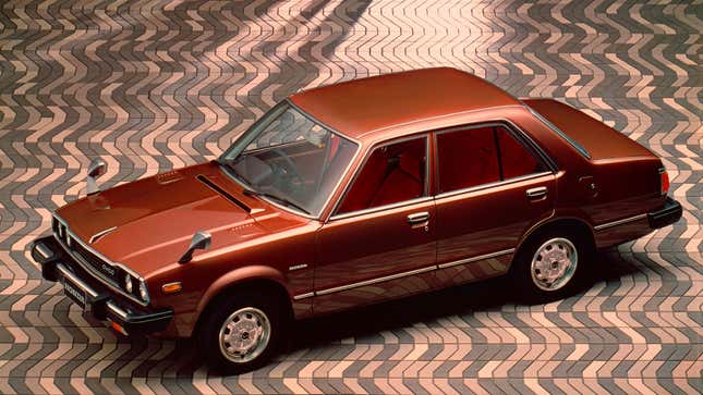 A photo of a brown Honda Accord sedan parked on a cobble street. 