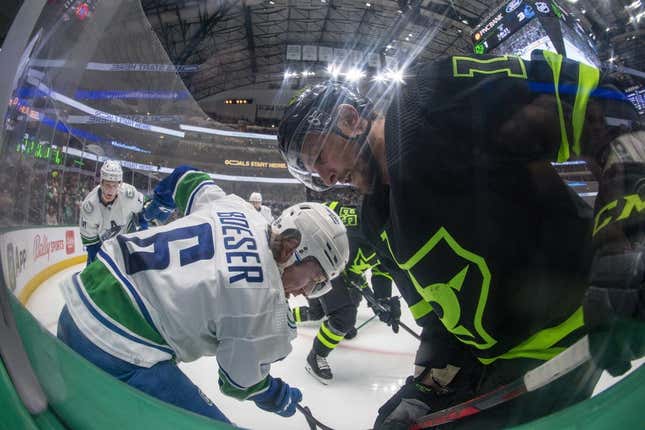 Mar 25, 2023; Dallas, Texas, USA; Dallas Stars center Luke Glendening (11) and Vancouver Canucks right wing Brock Boeser (6) battle for control of the puck during the second period at the American Airlines Center.
