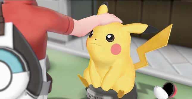 A trainer is shown petting Pikachu on the head as it sits on a table.