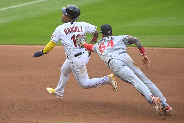 May 6, 2023; Cleveland, Ohio, USA; Cleveland Guardians third baseman Jose Ramirez (11) eludes a tag attempt by Minnesota Twins third baseman Jose Miranda (64) in the fourth inning at Progressive Field.