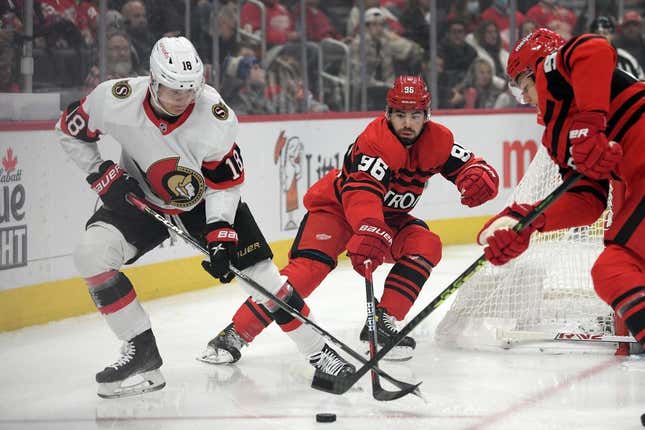 Dec 31, 2022; Detroit, Michigan, USA; Ottawa Senators left wing Tim Stutzle (18) battles for control of the puck with Detroit Red Wings defenseman Jake Walman (96) in the first period at Little Caesars Arena.