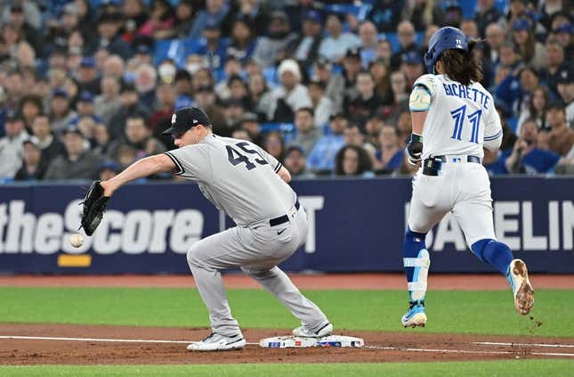 May 17, 2023; Toronto, Ontario, CAN;  New York Yankees pitcher Gerrit Cole (45) drops a throw to first base allowing Toronto Blue Jays shortstop Bo Bichette (11) to reach base safely in the first inning at Rogers Centre.