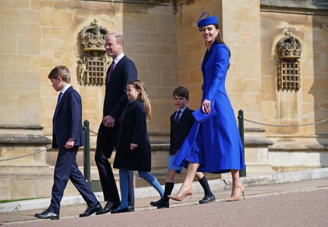 Prince George, Prince William, Princess Charlotte, Prince Louis, and Princess Catherine walk outside of Windsor Castle dressed in formal clothes.