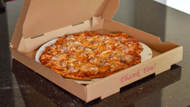 a sausage pizza in a takeout box