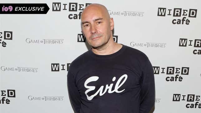 Grant Morrison, in a black sweatshirt labeled "Evil" stands at the Wired Cafe at Comic-Con