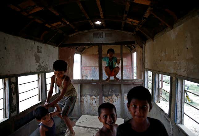 Children play inside an abandoned railway coach.