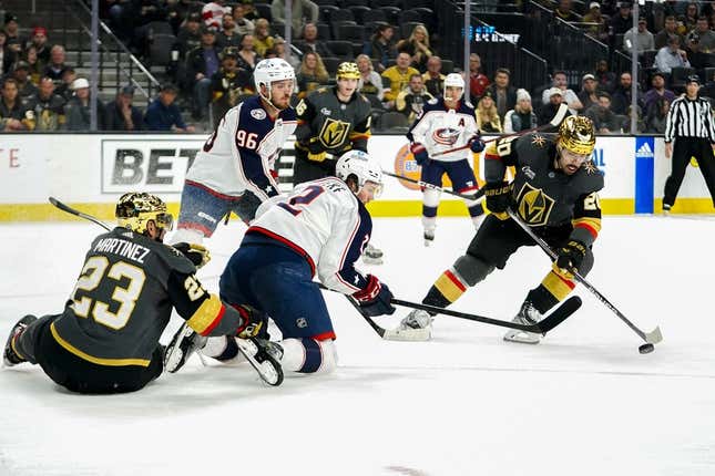 Mar 19, 2023; Las Vegas, Nevada, USA; Vegas Golden Knights center Chandler Stephenson (20) skates with the puck against Columbus Blue Jackets center Jack Roslovic (96) and defenseman Andrew Peeke (2) during the first period at T-Mobile Arena.