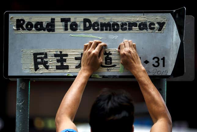 A worker removes masking tape left on a road sign by protesters during the clearance at the last Occupy protest site in Causeway Bay.